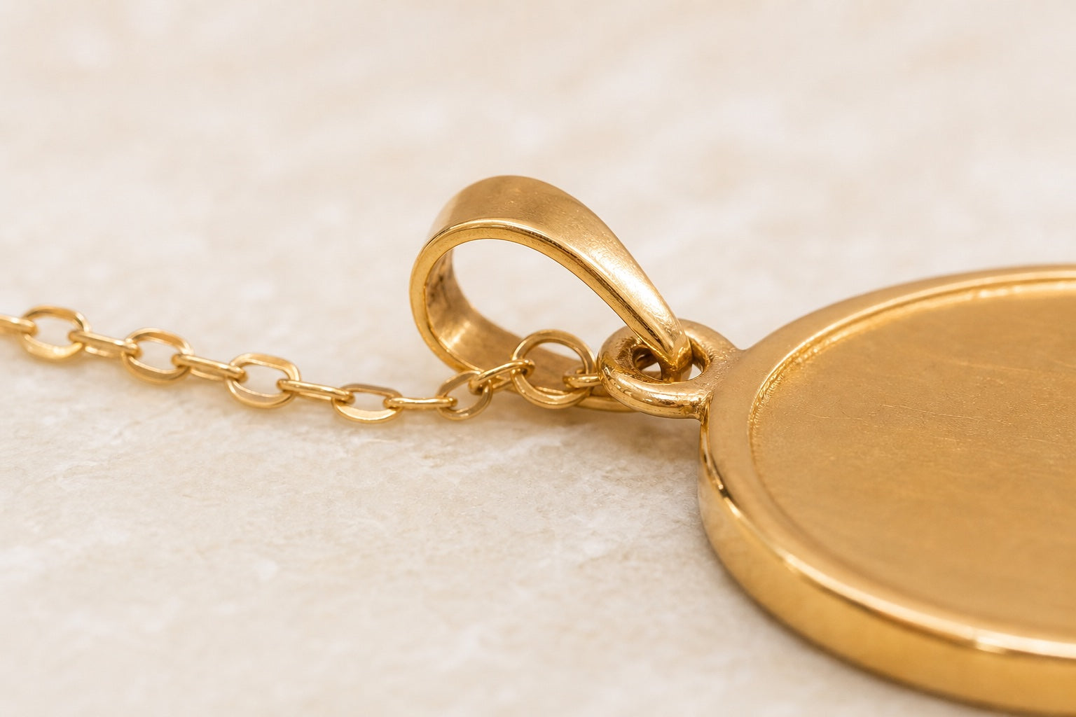 Anhänger neu vergolden lassen: Öse, Kante und Kettenaufnahme im Detail